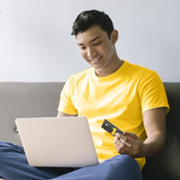 Man looking at credit card and computer.