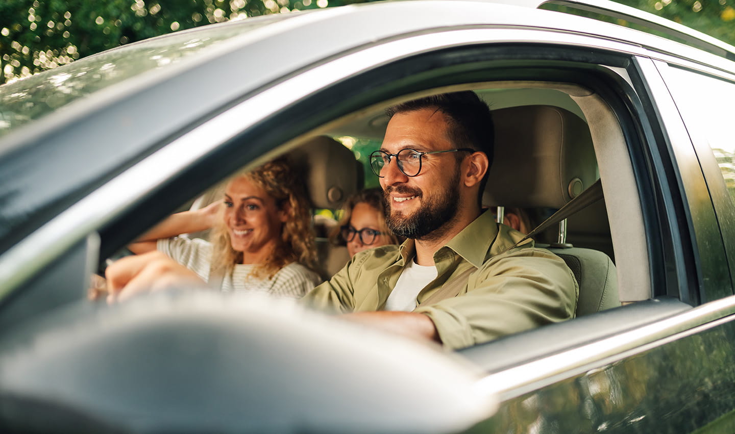 Husband driving with wife and daughter