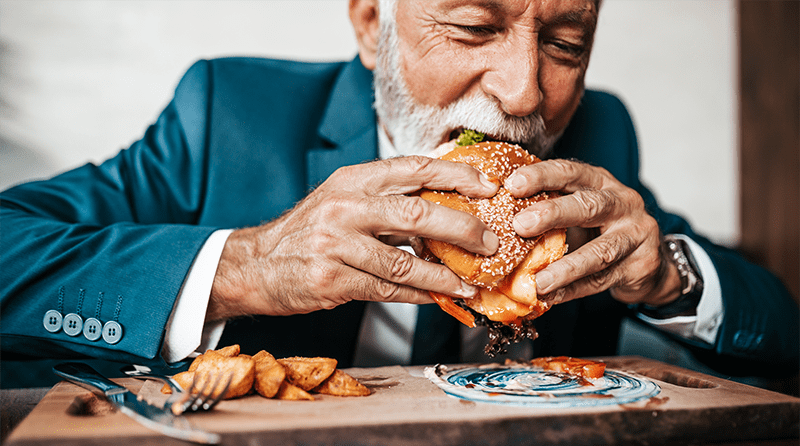 Man in suit enjoying eating a burger