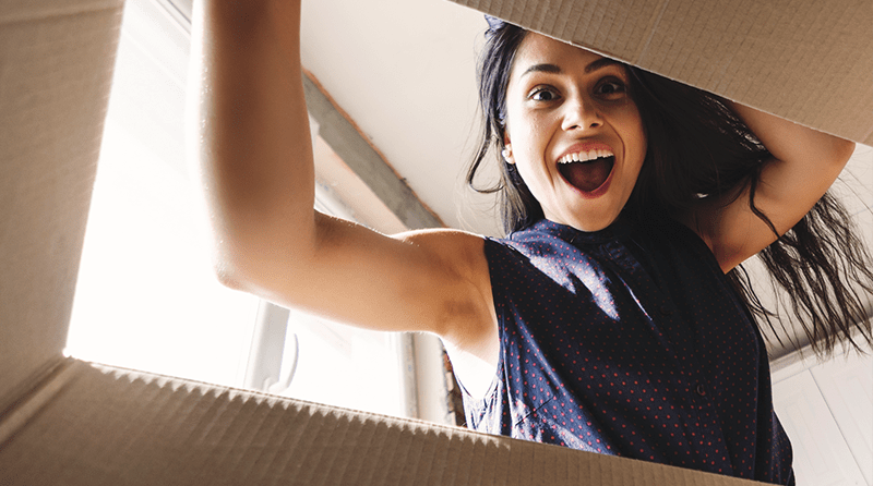 Excited woman opening a box 