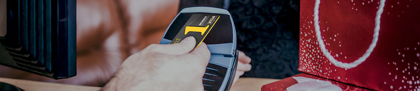 Hand holding a credit card to tap pay