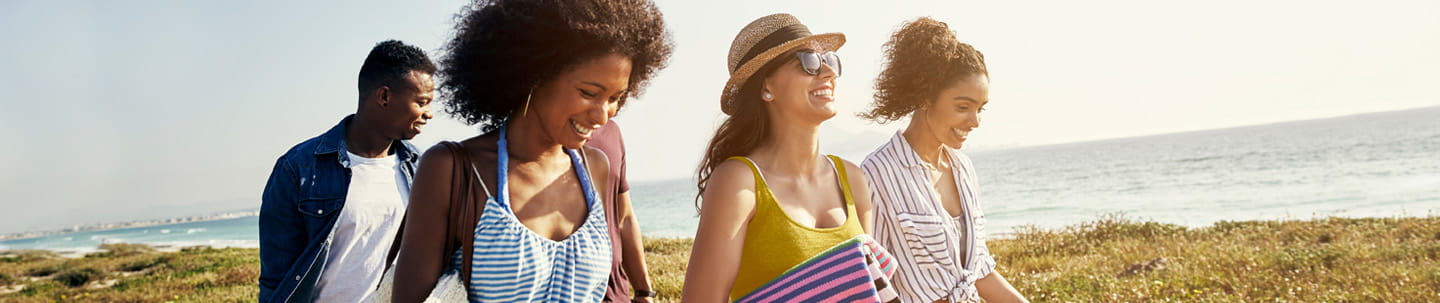 People smiling walking along the beach