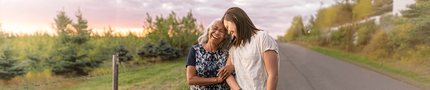 Two women locked arms walking outside smiling