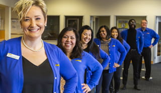Golden 1 employees in a branch standing in a row smiling