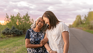 Two women locked arms walking outside smiling