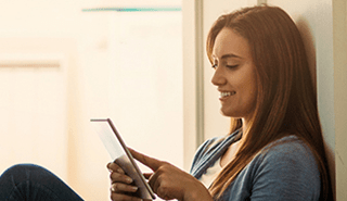 Woman sitting listening to podcasts on tablet