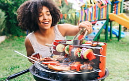 Woman cooking on backyard barbeque