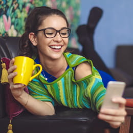 Young woman relaxing on couch and looking at phone