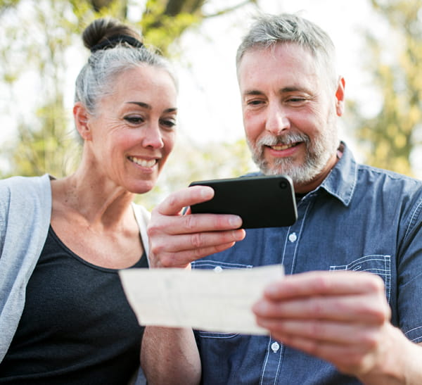 Woman standing next to man using a smartphone to scan a document
